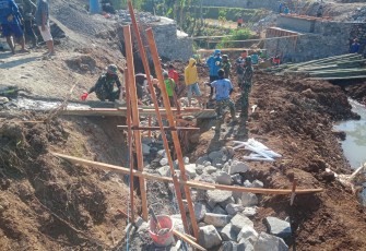 "Satgas TMMD Reg Mojogedang bersama warga sedang mengerjakan pekerjaan talud jalan"
