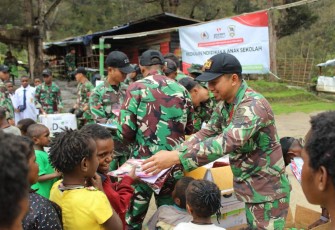Satgas Yonif Mekanis 203/AK Bekerja Sama dengan Artha Graha saat Bagikan Perlengkapan Sekolah Untuk Anak-Anak Pegunungan Tengah