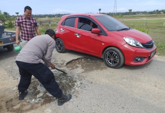 Kapolsek Nurussalam IPTU Mulyadi,SH.MH,bersama anggotanya dibantu masyarakat Desa Setempat melakukan penambalan jalan berlubang yang dianggap membahayakan para pengendara saat melintas