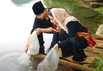 Bupati Trenggalek, Mochamad Nur Arifin, bersama istri, saat menebar 275 ribu benih ikan Tawes, di Kedung Robot, Desa Bogoran, Kecamatan Kampak, Kamis (30/11/2023)