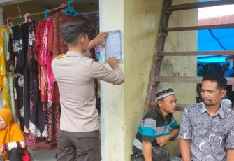 Personel Polsek Dolok menempel maklumat Kapolres Tapsel di sejumlah titik keramaian masyarakat.