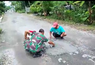 Babinsa Kodim 0802/Ponorogo saat Bantu Warga Kerja Bakti Perbaikan Jalan