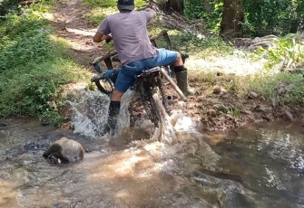 Dadang Nopian (32), salah satu warga Desa Kembang Ayun saat melintas di sungai kecil menuju kebunnya (sebelum sasaran Fisik TMMD ke-118 dimulai)