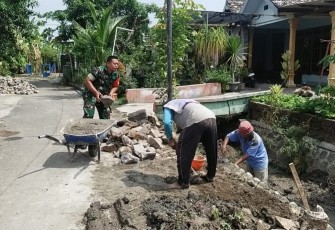 Babinsa saat Bantu Warga Perbaiki Saluran Irigasi di Rt 14/Rw 03 Desa Tempursari, Kecamatan Wungu, Kabupaten Madiun, Rabu (24/1/2024).