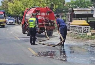 Polisi Jepara Gotong Royong Bersihkan Tumpahan Semen di Jalan