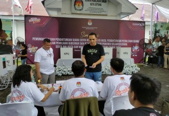 Ketua KPU Kota Bitung, Deslie D Sumampouw menggunakan Kaos Hitam saat mengambil surat suara yang akan di ceblos