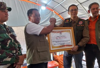 Deputi Bidang Penanganan Darurat BNPB Mayjen TNI Fajar Setyawan, S.I.P. (baju putih dengan rompi) secara simbolis memberikan dukungan bantuan penanganan bencana kepada Sekretaris Daerah Kabupaten Bandung di Kecamatan Rancaekek, Kabupaten Bandung, Jawa Barat, Jumat (23/2).