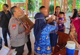 Babinsa Koramil 15/Kartoharjo saat Dampingi Imunisasi Polio Bagi Anak