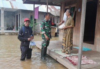 TNI Bersama Masyarakat saat Bantu Distribusi Sembako Untuk Korban Banjir Kalimantan Selatan