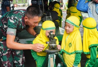 Siswi TK Islam Terpadu Al Ma'ruf mencoba teropong militer Yonarmed 11 Kostrad, Selasa (6/2)