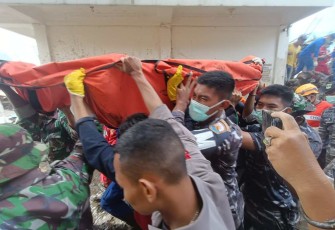 Prajurit TNI AL saat mengevakuasi jenazah korban banjir lahar dingin