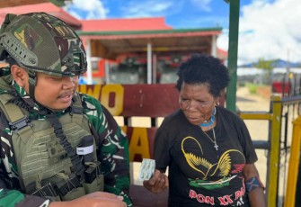 Mama Papua menerima obat dari dokter satgas yonif 509 Kostrad 