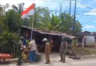 Satgas TMMD Menghimbau Warga Kibarkan Bendera Merah Putih.