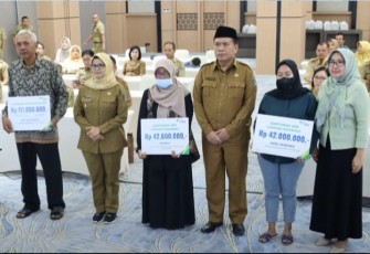 Bupati Blitar Rini Syarifah Didampingi Sekda Kabupaten Blitar Izul Marom Bersama Kepala BPJS Ketenagakerjaan Cabang Blitar Venina Sesuai Menyerahkan Santunan JKM dan Beasiswa kepada Peserta BPJS Ketenagakerjaan 