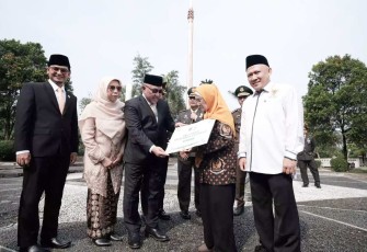 Wali Kota Depok, Mohammad Idris didamping Ketua BAZNAS Kota Depok, Endang Ahmad Yani (paling kanan) memberikan tali asih kepada salah satu Veteran, pada acara Peringatan Hari Pahlawan ke-79, di TMP Cilodong, Minggu (10/11/24).