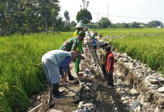 Babinsa saat Muneng Bantu Warga Bangun Saluran Irigasi, Minggu (21/1/2024).