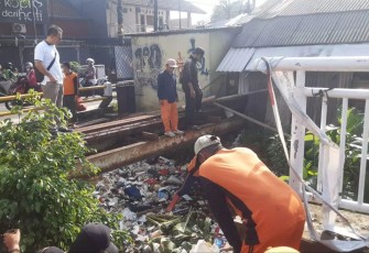Satgas DLHK Depok sedang membersihkan saluran air yang tersumbat sampah, Selasa (19/11)