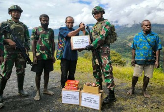 Satgas Pamtas Mobile RI-PNG Yonif 323/Buaya Putih Kostrad Pimpinan Lettu Inf Arif Agung Caroko memberikan bantuan kepada saudara pedalaman papua di Kampung Wombru, Distrik Mege'abume, Kab Puncak, Papua, Jumat (08/03/2024).