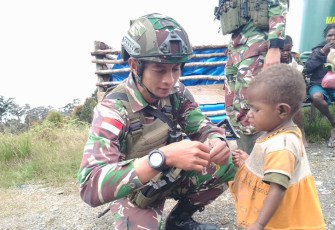 Satgas Yonif 509 Kostrad saat Bagikan Makanan pada seorang anak di Intan Jaya, Papua
