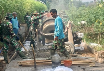 Prajurit TNI bahu-membahu dengan warga desa membangun jalan penghubung
