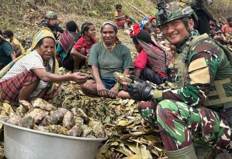 Satgas TNI Menyatu Bersama Warga Wombru dalam Tradisi Bakar Batu 