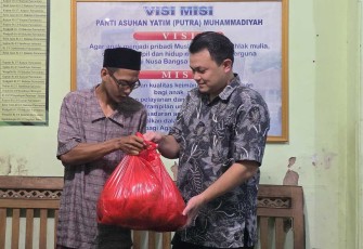 Setiawan AD 1 PM saat menyerahkan ikan segar ke pengasuh panti asuhan putra Muhammadiyah Wonogiri, Minggu (6/4)