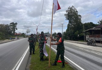Anggota Kodim 1710/Mimika yang dipimpin oleh Danramil 1710-06/Agimuga, Lettu Inf A.A. Rumayom terlihat bersemangat memasang bendera merah putih satu per satu