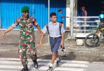 Babinsa Timika Bantu Lalu Lintas Penyeberangan Anak Sekolah