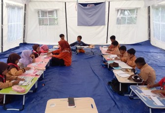 Para siswa belaja di tenda ruang kelas darurat.