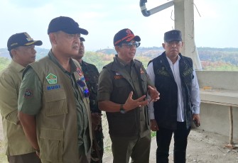 Kepala BNPB Letjen TNI Dr. Suharyanto, S. Sos., M.M., (kemeja dan rompi hijau) saat meninjau pemadaman kebakaran hutan dan lahan menggunakan helikopter water bombing BNPB di wilayah Kecamatan Rambah Kabupaten Rokan Hulu, Provinsi Riau pada Kamis (24/7).
