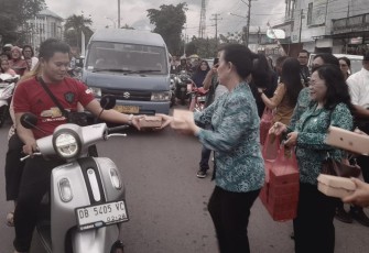 Ketua TP PKK Kota Bitung, Ny. Ellen Sondakh saat membagikan takjil kepada pengendara yang sedang menjalankan ibadah puasa