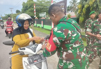 Anggota Koramil Timika Bagikan Bendera Merah Putih Bagi Pengguna Jalan