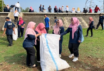 Para pegawai Diskominfo Karanganyar bergotong royong membersihkan sampah di kawasan Waduk Delingan, Jumat (8/8/2025).
