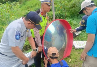 Petugas gabungan sedang memasang convex mirror di salah satu titik rawan kecelakaan di jalur kawasan wisata Tawangmangu.