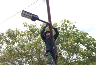 Prajurit TNI Pasang Lampu Tenaga Surya