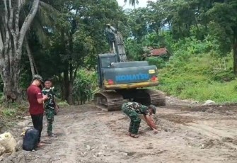 Personil Satgas TMMD dengan menggunakan excavator melakukan pemerataan dan pengerasan badan jalan program TMMD Ke-123 Kodim 1310/Bitung
