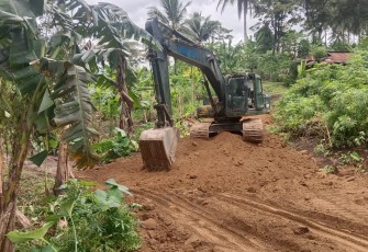 Satgas TMMD Ke-123 Kodim 1310/Bitung saat melakukan pengerasan badan jalan program TMMD dengan menggunakan excavator