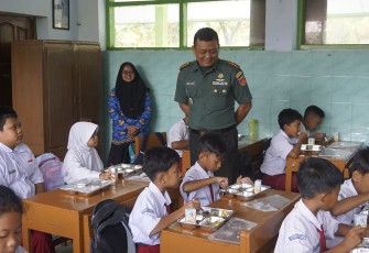 Dandim 0727/Karanganyar Letkol Inf Andri Army Yudha Ardhitama melihat para siswa SDN 1 Popongan yang sedang menyantap makanan bergizi di sela kegiatan Launching Dapur Mandiri Hybrid Yayasan Oda Masa Depan Utama, Senin (17/2/2025)