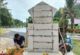 Satgas TMMD ke-123 Kodim 1708/BN bersama warga buat tugu prasasti di lokasi pintu masuk pembangunan 10 unit rumah warga Kampung Kbusdori