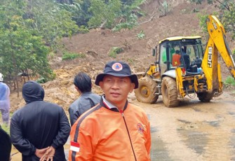 Pembersihan material longsor yang menutup badan jalan.