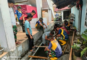 Personel Satgas TMMD Kodim 1310/Bitung bersama warga saat menggelar Karya bakti bersih-bersih lingkungan pasar dan perbaikan saluran air