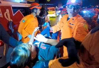 Personel Basarnas Surakarta mengevakuasi Rizki Dwi Saputra (20), pengemudi mobil pikap Daihatsu Gran Max yang mengalami kecelakaan di Jalan Raya Ahmad Yani kawasan Manahan, Kota Surakarta,  Senin (9/2/2026) malam.