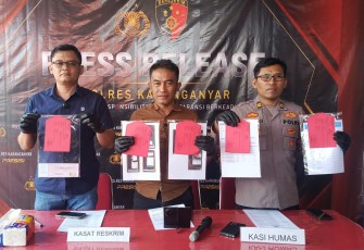 Kasat Reskrim AKP Wikan Sri Kadiyono (tengah), didampingi Kanit II Satreskrim Iptu Anjar Wardoyo dan Kasi Humas Iptu Mulyadi , menunjukkan barang bukti kasus penipuan rekrutmen BLUD RSUD Karanganyar saat konferensi pers di Mapolres Karanganyar, Kamis (30/7/2026).