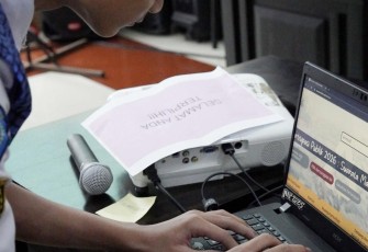 Ilustrasi siswa membuka kamus digital bahasa Makassar 