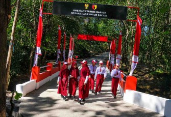 Suka cita anak-anak melintasi jembatan perintis garuda