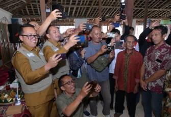 Bupati Karanganyar Rober Christanto dan Wakil Bupati Adhe Eliana, melakukan simulasi peran sebagai awak media saat peringatan HPN 2026 sekaligus penyerahan bantuan kepada warga korban bencana alam, di Pendopo Desa Wonokeling, Kecamatan Jatiyoso, Senin (9/2/2026)