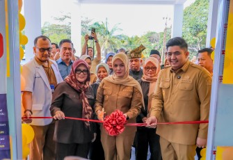 Pemotongan pita sebagai simbol dimulainya operasional fasilitas pelayanan kesehatan baru.