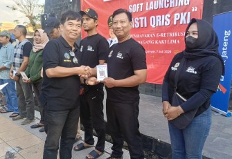 Penyerahan akrilik kode Qris secara simbolis oleh Kepala Diskuktrans ESDM Karanganyar, Sriono Budi Santoso kepada pedagang kaki lima di kawasan Taman Pancasila Karanganyar, Selasa (7/7/2026)