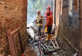 Petugas melakukan proses pendinginan di lokasi kebakaran rumah milik Erna (30), di Dusun Tirto RT 01 RW 12, Bolong, Karanganyar, Kamis pagi (9/7/2026)