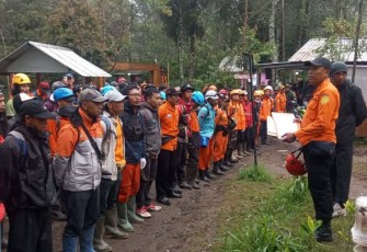 Komandan Regu Basarnas Surakarta, Tri Puji Sugiarto, memberikan pengarahan kepada personel tim SAR gabungan terkait pencarian lanjutan terhadap Yasid Ahmad Firdaus (26) di Bukit Mongkrang, Gondosuli, Tawangmangu.